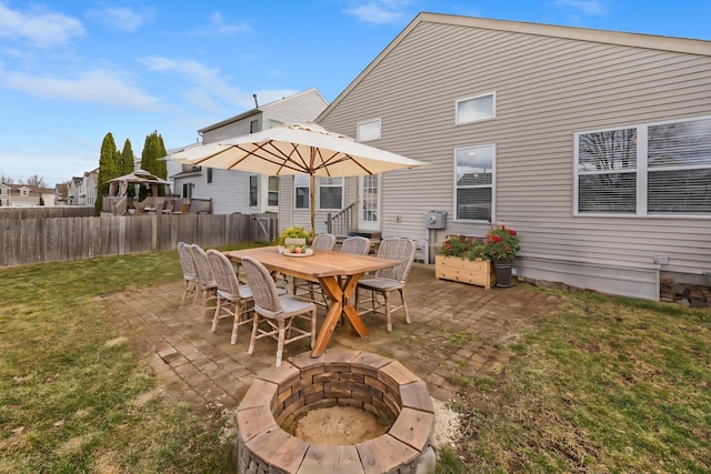 rear view of house with a fire pit, fence, a lawn, and a patio