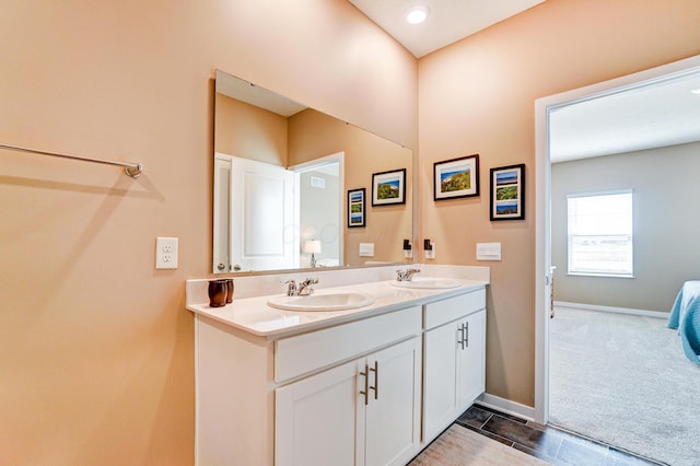 bathroom featuring double vanity, a sink, and baseboards