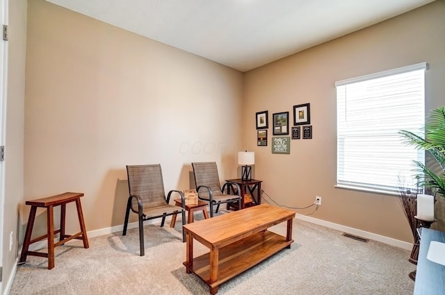 sitting room with light carpet, visible vents, and baseboards