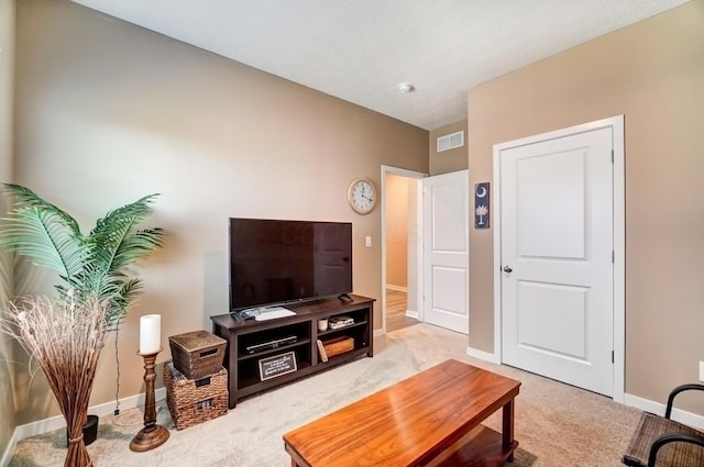 living area with light carpet, baseboards, and visible vents