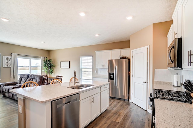 kitchen featuring a healthy amount of sunlight, appliances with stainless steel finishes, dark wood-type flooring, and a sink