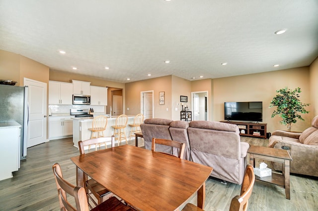 dining space with wood finished floors and recessed lighting