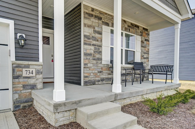 doorway to property with covered porch and stone siding