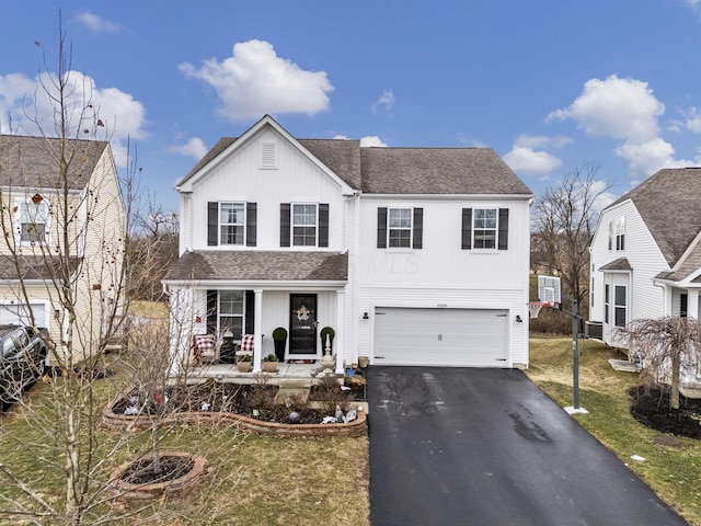 traditional-style home featuring driveway, a porch, an attached garage, and a shingled roof