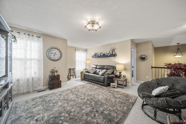 carpeted living area with baseboards, visible vents, and a textured ceiling