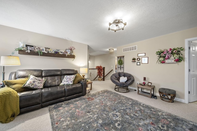 carpeted living room featuring a textured ceiling, visible vents, and baseboards