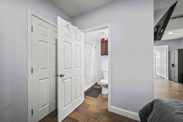 bedroom with baseboards, visible vents, and wood finished floors