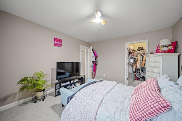 bedroom featuring a spacious closet, a closet, carpet, and baseboards