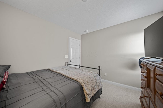 bedroom featuring a textured ceiling, carpet floors, and baseboards