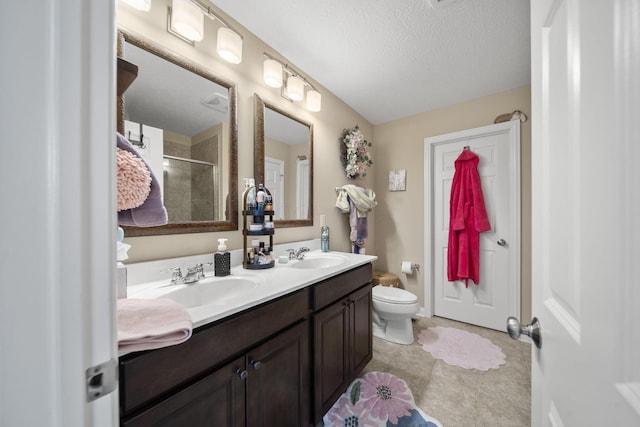 full bath with a stall shower, a sink, toilet, and double vanity