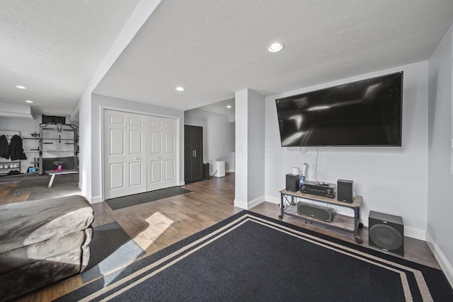 living area with baseboards, a textured ceiling, wood finished floors, and recessed lighting