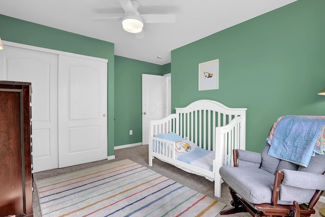 bedroom featuring ceiling fan, a closet, carpet, and baseboards