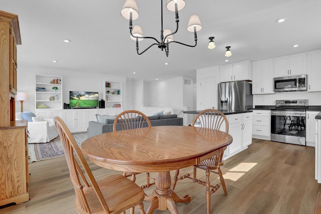 dining room with light wood-style floors, recessed lighting, built in features, and an inviting chandelier