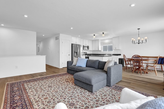 living room with wood finished floors, visible vents, and recessed lighting