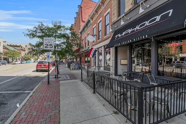 view of road with curbs, street lighting, traffic signs, and sidewalks