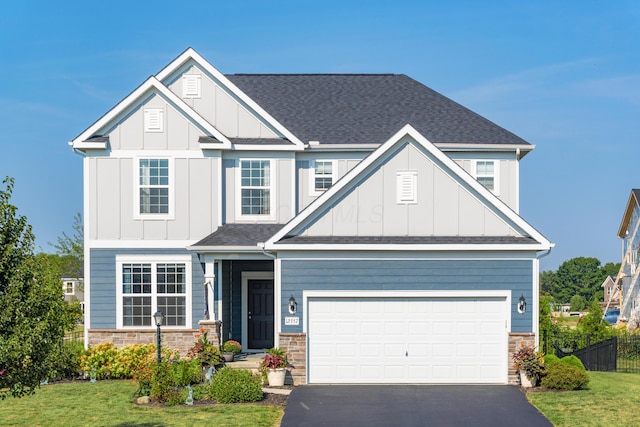 craftsman inspired home with stone siding, fence, aphalt driveway, and board and batten siding