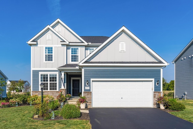 craftsman house with driveway, stone siding, an attached garage, and board and batten siding