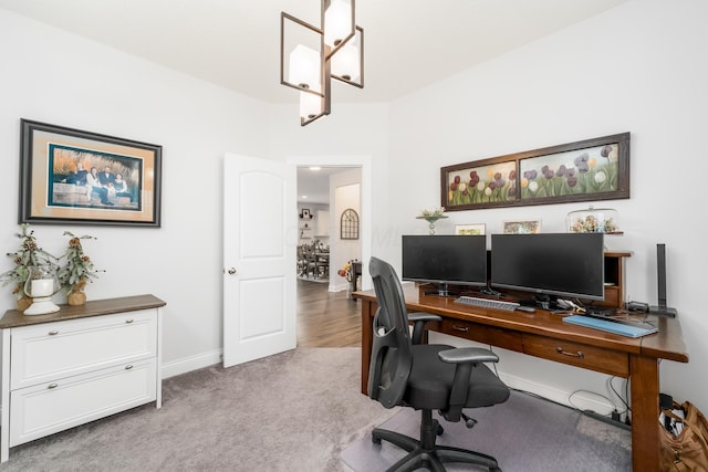 office space with carpet, a chandelier, and baseboards