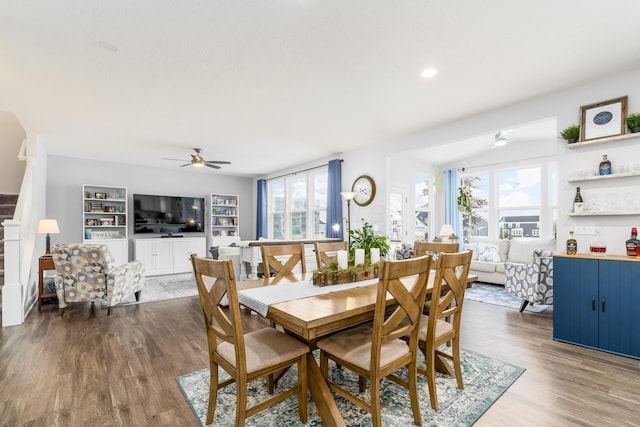 dining room featuring ceiling fan, stairway, and wood finished floors