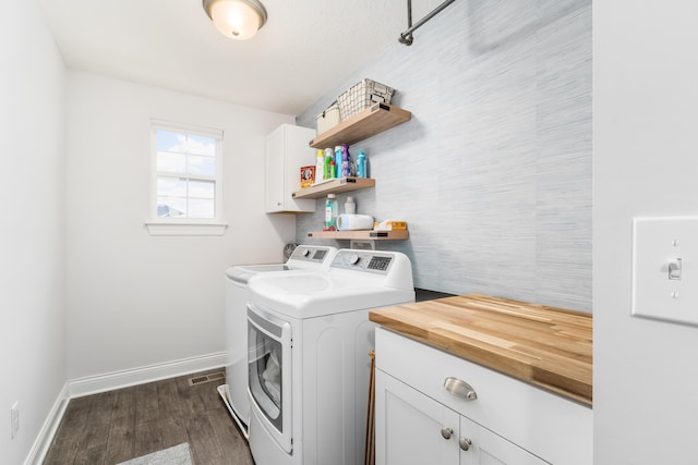 laundry area with dark wood-style floors, baseboards, separate washer and dryer, and cabinet space