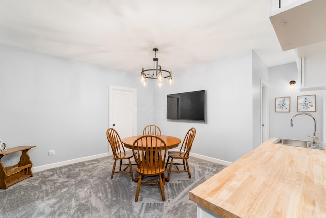 dining space featuring carpet flooring, baseboards, and an inviting chandelier