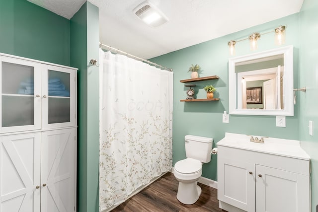 bathroom with curtained shower, visible vents, toilet, vanity, and wood finished floors