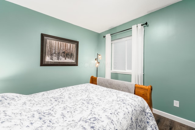 bedroom featuring baseboards and dark wood-style flooring