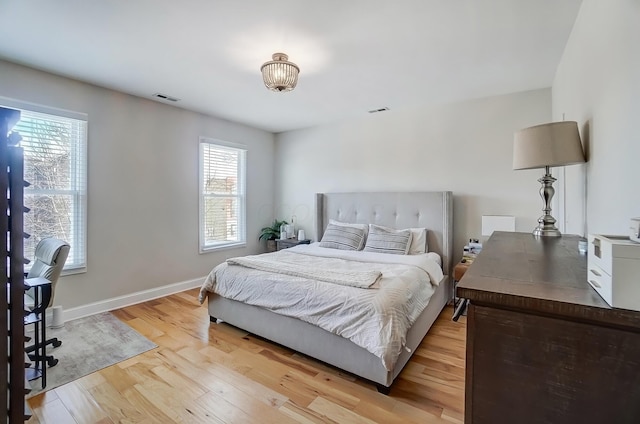 bedroom featuring baseboards, visible vents, and light wood-style floors