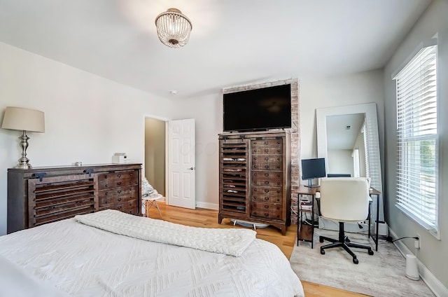 bedroom with baseboards and wood finished floors