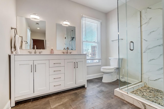 full bathroom with toilet, a shower stall, baseboards, and a sink