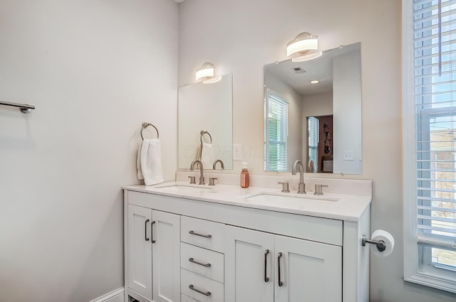 bathroom with double vanity, visible vents, and a sink