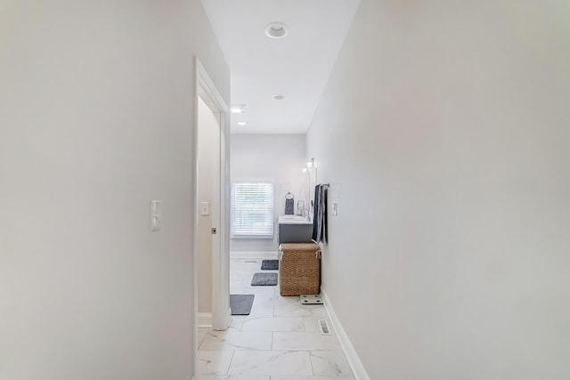 hallway with marble finish floor, recessed lighting, and baseboards