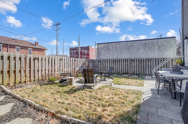 view of yard with an outdoor fire pit, a fenced backyard, and a patio