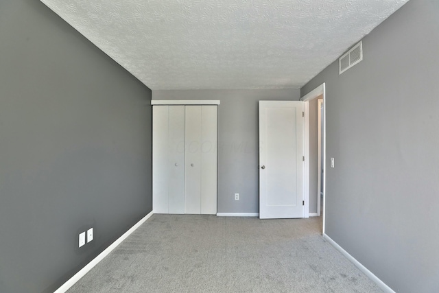 unfurnished bedroom with carpet floors, a closet, visible vents, and baseboards