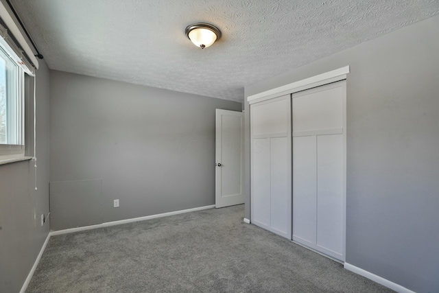 unfurnished bedroom with carpet, baseboards, and a closet