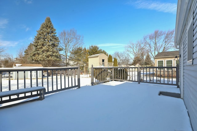 snow covered deck featuring an outbuilding