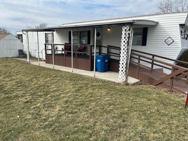 back of house with a patio area, a yard, a shed, and an outdoor structure