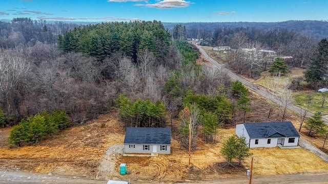 drone / aerial view featuring a wooded view