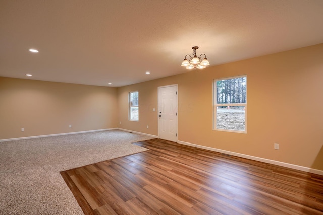 interior space with a notable chandelier, recessed lighting, wood finished floors, and baseboards