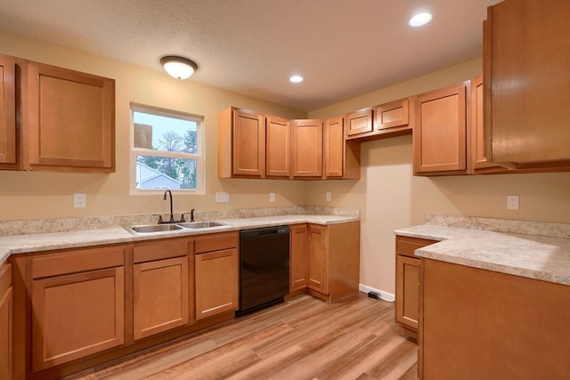 kitchen featuring a textured ceiling, a sink, light wood-style floors, light countertops, and dishwasher