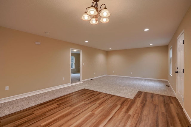 unfurnished room featuring baseboards, wood finished floors, and recessed lighting