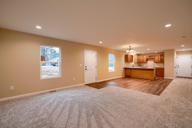 kitchen with open floor plan, carpet floors, recessed lighting, and brown cabinets