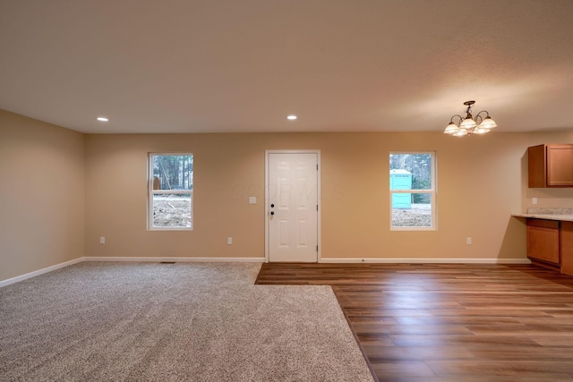 interior space with an inviting chandelier, baseboards, a wealth of natural light, and recessed lighting