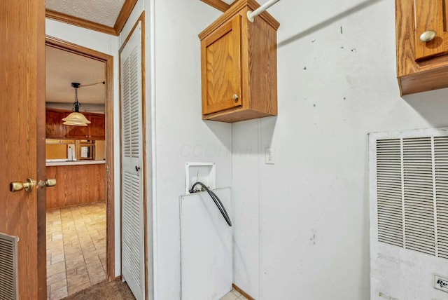 washroom featuring cabinet space, a heating unit, and washer hookup