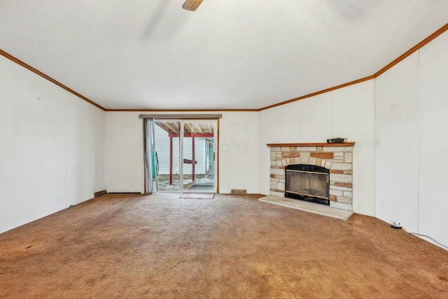 unfurnished living room featuring a textured ceiling, a stone fireplace, ornamental molding, and carpet flooring