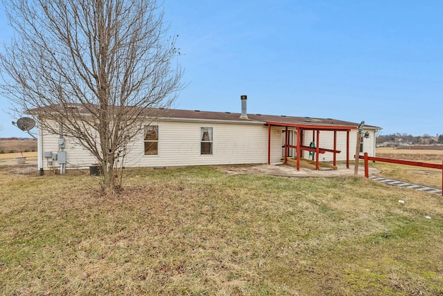 rear view of property with a lawn and a patio area