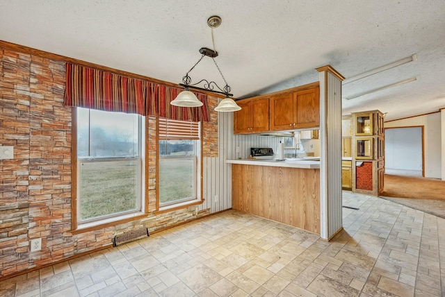 kitchen with a textured ceiling, a sink, visible vents, light countertops, and decorative light fixtures