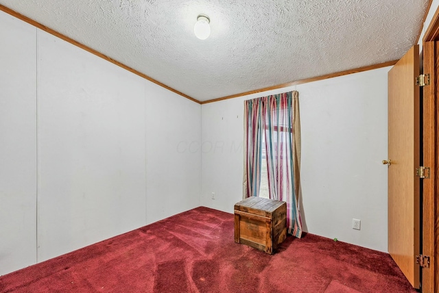 carpeted spare room featuring ornamental molding and a textured ceiling