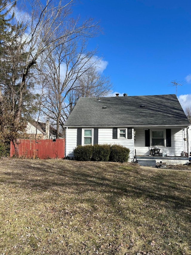 rear view of house with a lawn and fence