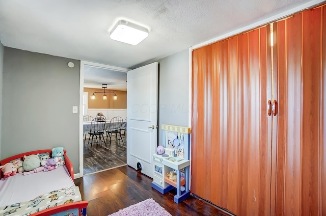 bedroom featuring dark wood-style floors and a textured ceiling